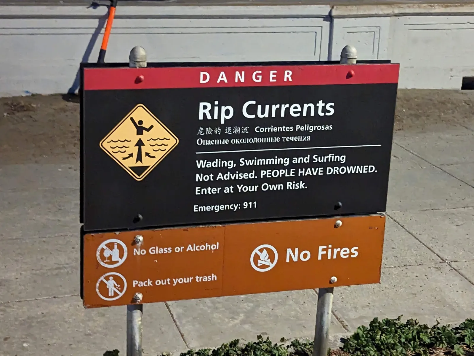 Danger sign at Ocean Beach warning of rip currents